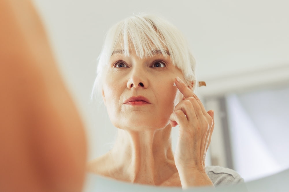 senior woman looking in mirror